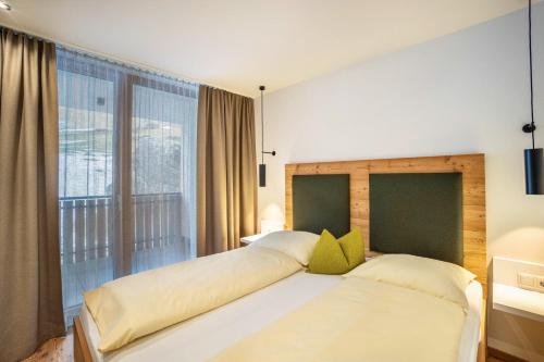 a bedroom with two beds and a large window at Stoana Apt 4-1 in San Giacomo