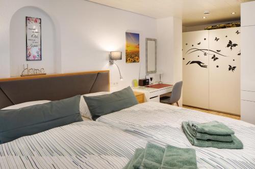 a bedroom with a bed and a desk at Gelis Ferienwohnung in Ihringen