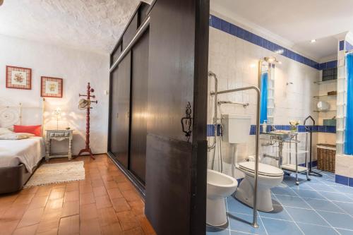 a bathroom with a shower and a toilet and a bed at Villa Morena in Albufeira