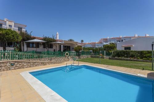 a large blue swimming pool in front of some houses at Villa Morena in Albufeira