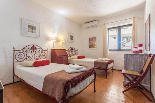 a hotel room with two beds and a window at Villa Morena in Albufeira