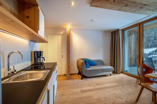 a kitchen with a sink and a chair in a room at Stoana Apt 3-2 in San Giacomo