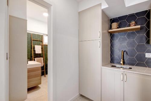 a kitchen with white cabinets and a sink at Apartamento Brisas Do Mar in Porches