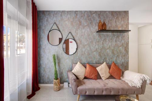 a living room with a couch and some mirrors at Apartamento Brisas Do Mar in Porches
