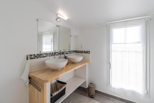 a bathroom with two sinks and a mirror at Le Séchoir in Saint-Amand-de-Coly