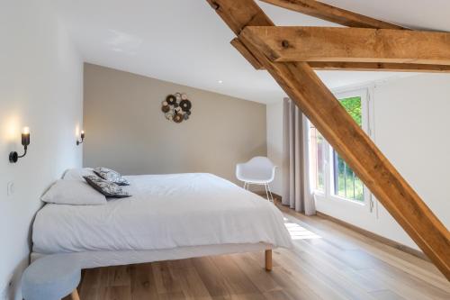 a bedroom with white walls and wooden beams at Le Séchoir in Saint-Amand-de-Coly