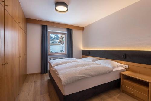 a bedroom with a large bed and a window at La Grambla App Mont Seuc in Santa Cristina Gherdëina
