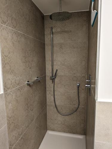 a shower with a hose in a bathroom at Apartment Bergzeit Sterzing in Vipiteno