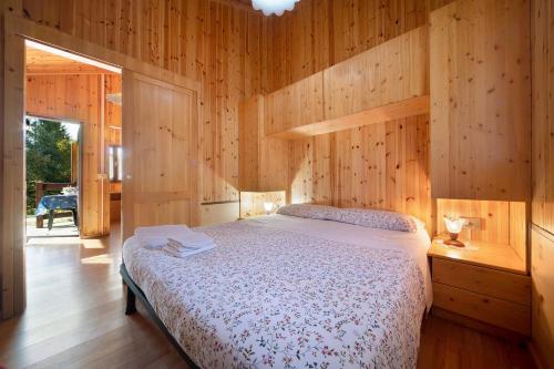 a bedroom with a bed in a wooden wall at Casa Genziana in Barzio