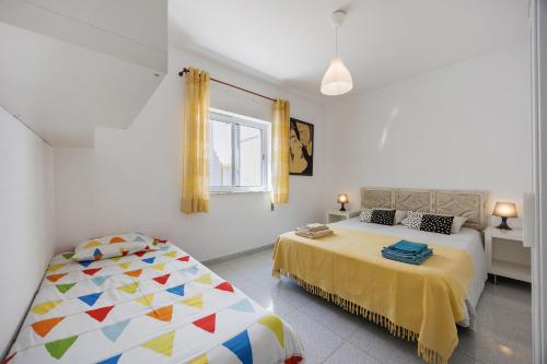 a bedroom with two beds and a window at Apartamento Carrapateira in Bordeira
