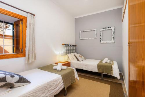 a bedroom with two beds and a window at Can Tiro in Islas Baleares