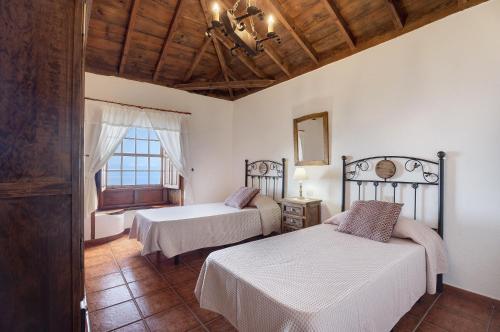 a bedroom with two beds and a window at Casa El Naranjo Viejo in Tijarafe