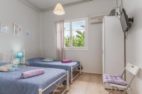 a hospital room with two beds and a window at Stenies Little Nook in Andros
