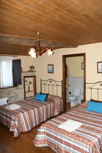 a bedroom with two beds and a bathroom at O Bolaño Apt 1 in Villarino de Conso