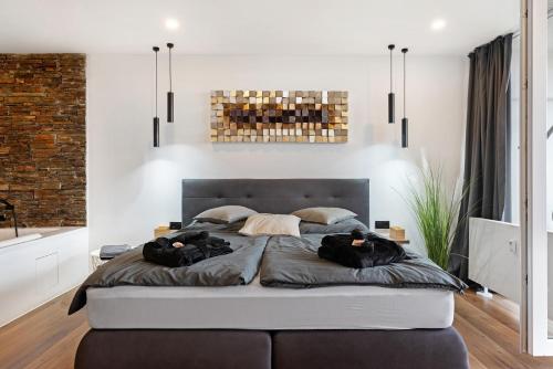 a bedroom with a large bed with two people on it at Luxus Appartement mit Panoramablick in Sinsheim