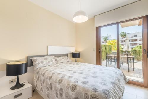 a bedroom with a bed and a balcony at Terrazas de Campoamor Sunrise in Orihuela