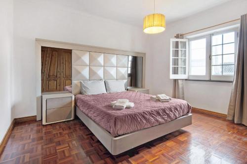 a bedroom with a bed with a purple comforter at Pascoal House in Ribeira Grande