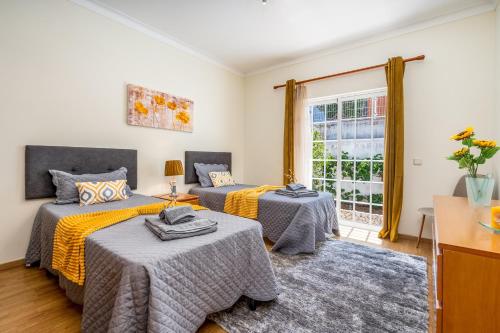 a bedroom with two beds and a window at Casa Village in Senhora do Verde
