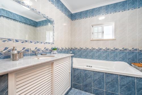 a bathroom with a tub and a sink at Casa Village in Senhora do Verde