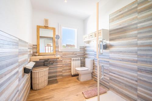 a bathroom with a toilet and a mirror at Casa Cala Santanyí in Santanyi