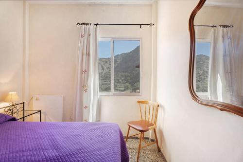 a bedroom with a purple bed and a mirror at Casa de Berta in Vallehermoso
