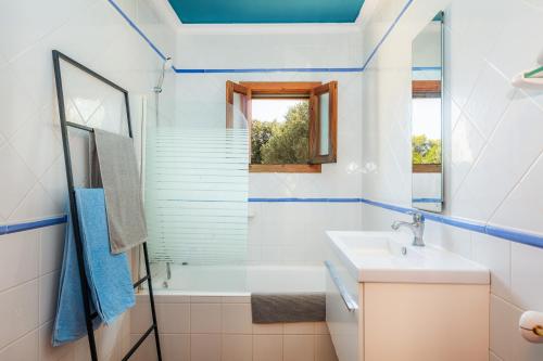 a bathroom with a sink and a tub and a window at Sa Plana in Son Servera