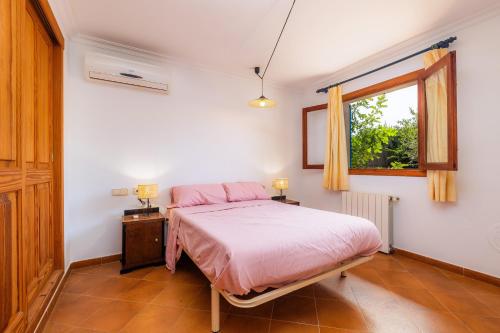 a bedroom with a bed and a window at Sa Plana in Son Servera