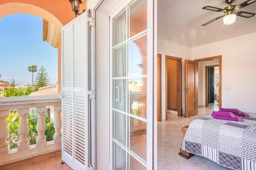a bedroom with a bed and a balcony at Casa las Bahias in Llucmajor
