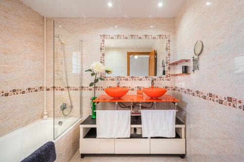 a bathroom with two sinks and a tub and a mirror at Casa las Bahias in Llucmajor