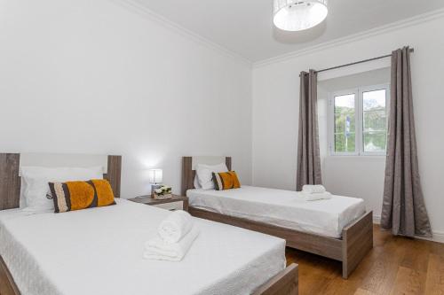 a bedroom with two beds and a window at Oásis Fonte Grande in Santo António