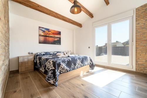 a bedroom with a bed and a large window at Casa rural Maño in Deltebre