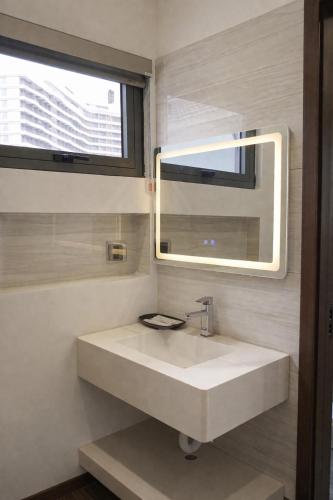 a bathroom with a white sink and a mirror at V3K03 Sonasea Vân Đồn in Thâm Câu