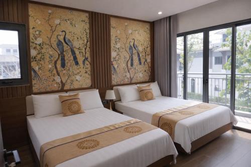 two beds in a hotel room with windows at V3K03 Sonasea Vân Đồn in Thâm Câu