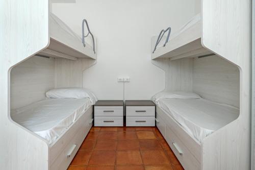 two bunk beds in a room with a tile floor at Trilo Piazzetta Garden in San Teodoro