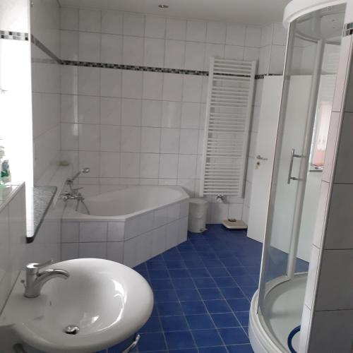 a bathroom with a sink and a tub and a toilet at Backstubencafe Beck in Ansbach