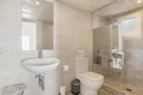 a white bathroom with a sink and a toilet at Finca El Porvenir in El Gastor