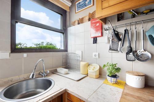 a kitchen with a sink and a window at Casa da Ria 78 - Family House in Torreira