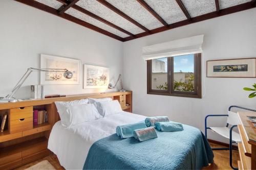 a bedroom with a bed and a desk and a window at Casa da Ria 78 - Family House in Torreira
