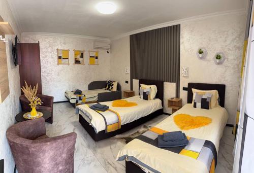 a hotel room with three beds and a chair at Villa Magnat in Berehove