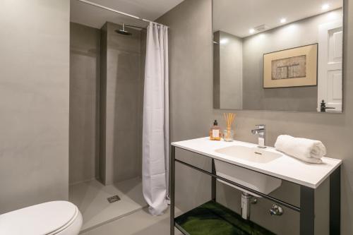 a bathroom with a toilet and a sink and a shower at Almela's in Santa Pola