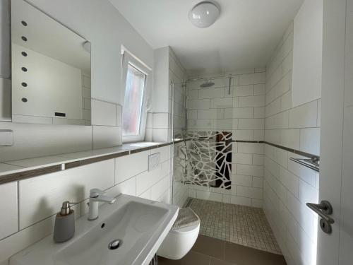 a white bathroom with a sink and a toilet at Ferienhaus Specht in Zossen