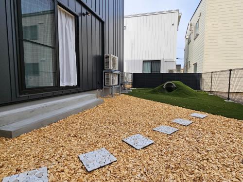 a backyard with rocks on the ground in front of a building at Kuro in Hakodate