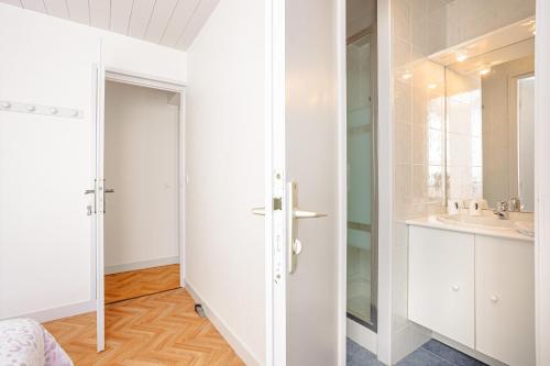 a white bathroom with a sink and a mirror at Chambres d’hôtes Chantal Hereaudeau in Ars-en-Ré