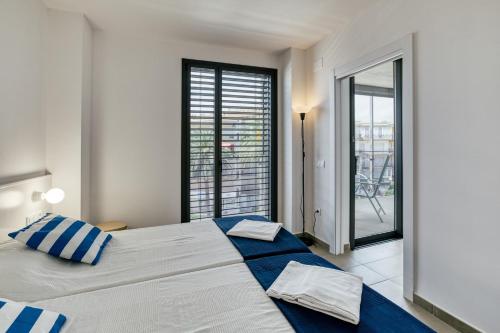 a bedroom with a large bed and a large window at Rostella Apartment in Roses