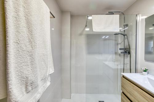 a white bathroom with a shower and a sink at Rostella Apartment in Roses