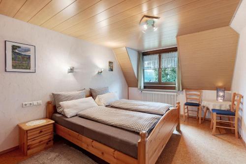 a bedroom with a bed and a table and chairs at Ferienwohnung Schweizer in Bernau im Schwarzwald