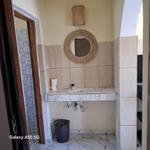 a bathroom with a sink and a mirror at Orange apartments 3 in Watamu