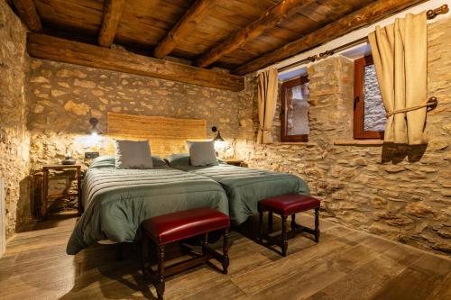 a bedroom with a bed in a stone wall at Masía Parreta Estancia El Refugio in Villafranca del Cid