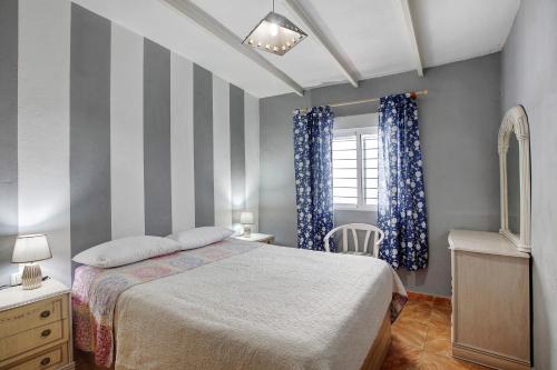 a bedroom with a bed and a striped wall at Casa Marrero in La Guancha