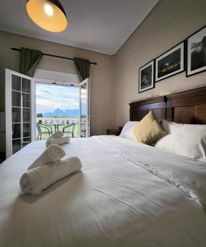 a bedroom with a large white bed with towels on it at Spilaio at Meteora in Kalabaka